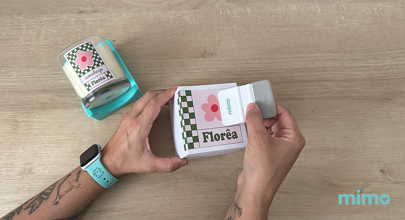Passando a espátula Mimo para fixar melhor a arte na embalagem personalizada