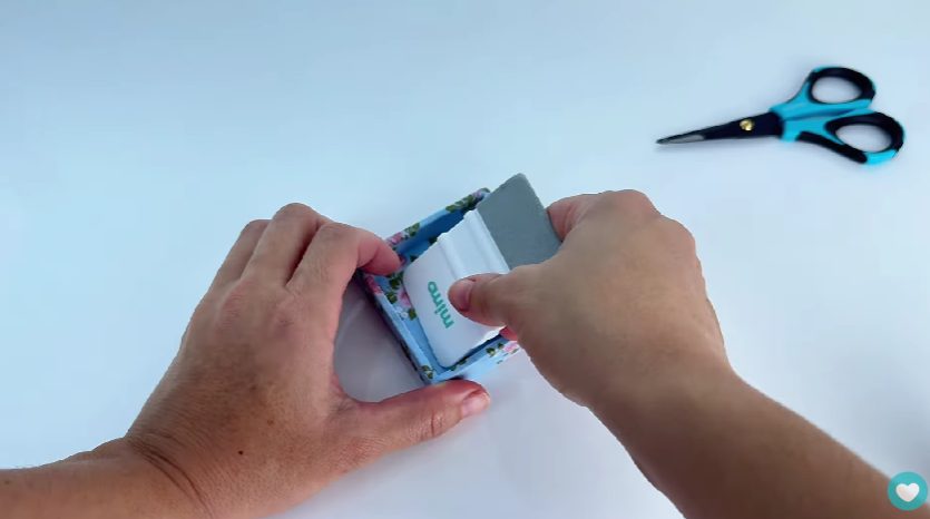 Finalizando a colagem do tecido com a Espátula
