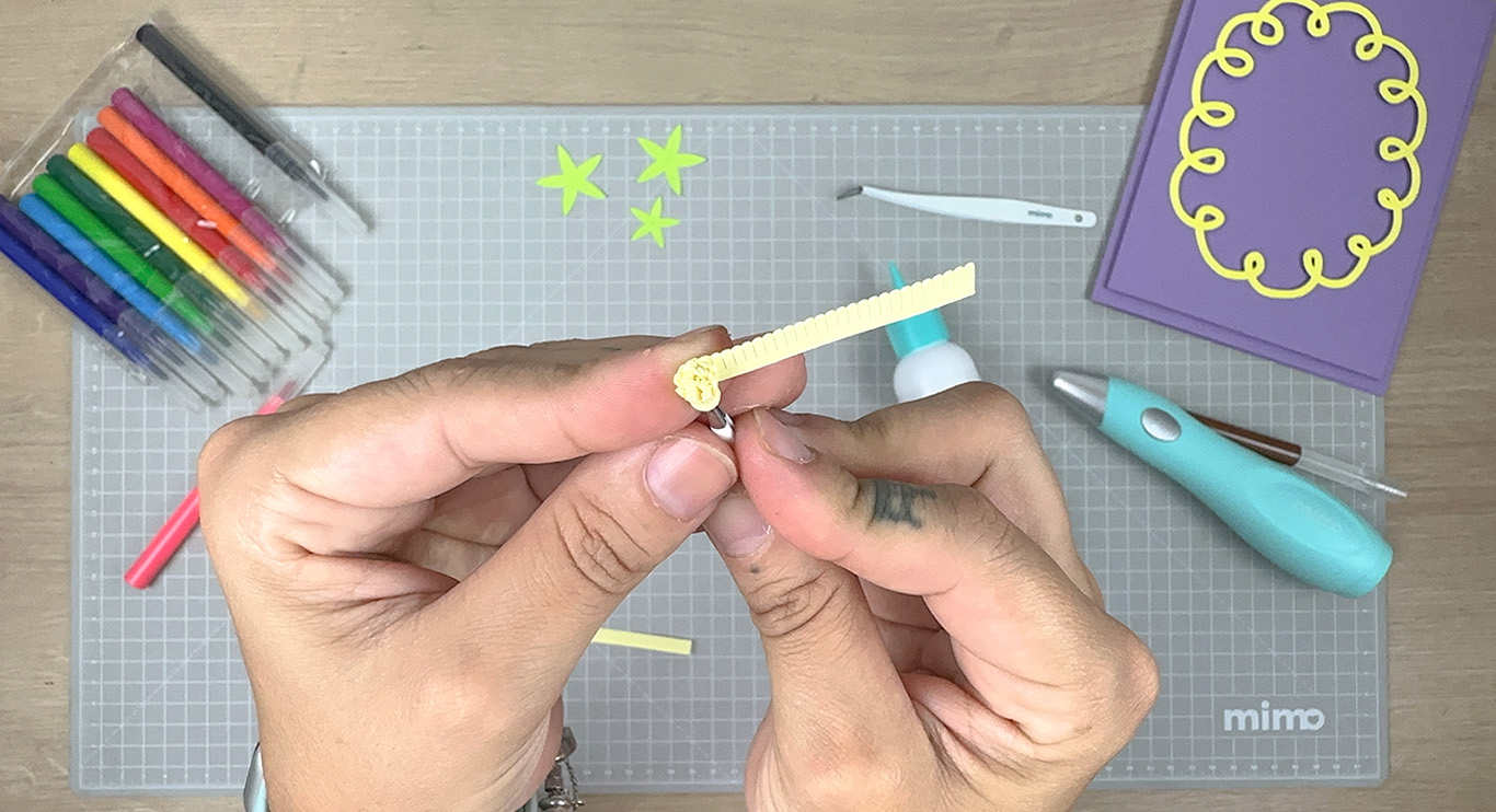 Enrolando papel par fazer o miolo da flor