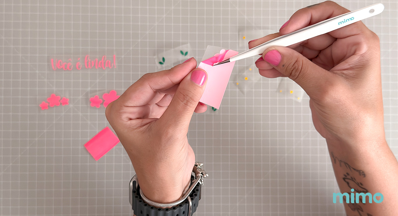 Usando a pinça de precisão para retirar os excessos de vinil Usando a pinça de precisão para retirar os excessos de vinil